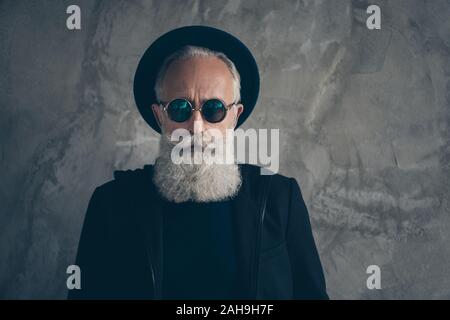 Nahaufnahme Foto von brutalen rauen männlichen alter Mann stare in Specs tragen hat Mantel über grauer Hintergrund Stockfoto