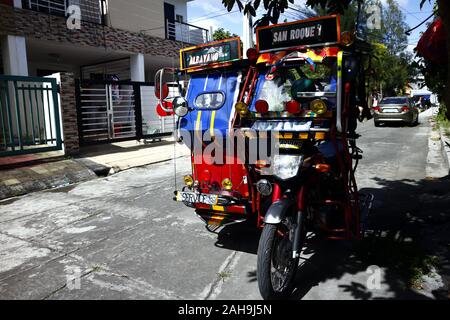 Antipolo City, Philippinen - Dezember 19, 2019: eingerichtet und farbenfroh Passagier Dreirad unter dem Schatten eines Baumes durch einen Bürgersteig geparkt. Stockfoto