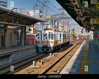 Ein modernes, Lokale, elektrische S-Bahn auf einen leeren Bahnsteig Bahnhof Nagoya an einem hellen, sonnigen Morgen im November. Stockfoto