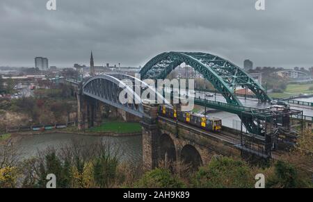 Nexus Tyne und Wear metro Überqueren der Brücke Monkwearmouth, Sunderland (Fluss Wear) an trüben, nassen Winter Tag Stockfoto