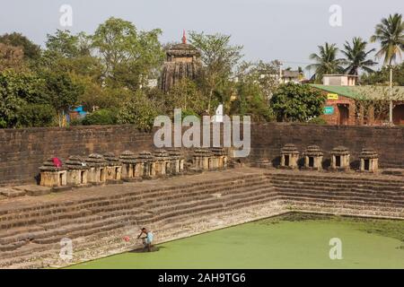 Bhubaneshwar, Orissa, Indien - Februar 2018: Ein alter hinduistischer Tempeltank, der mit kleinen Schreinen um das Vorgebirge über den Stufen, die zu führen, gesäumt ist Stockfoto