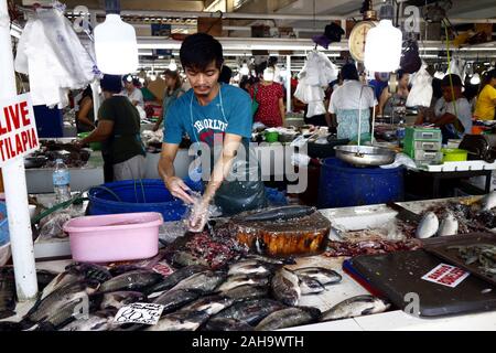 Antipolo City, Philippinen - Dezember 23, 2019: Anbieter bei einer öffentlichen Wet Market Fisch und andere Meeresfrüchte zu Kunden. Stockfoto