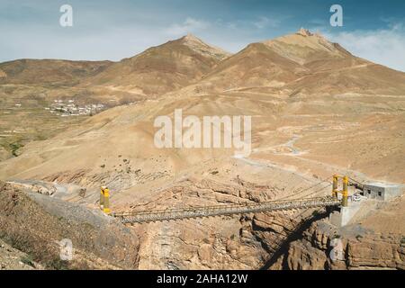 Spiti chicham Brücke über Fluss und Blick auf das Dorf im Himalaya auf einem hellen Sommertag unter blauem Himmel in Himachal Pradesh, Indien verschachtelt. Stockfoto