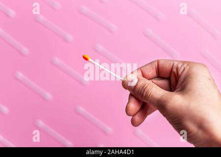 Person halten eine hygiene Baumwolle stick voll Blut. Kosmetik Konzept. Blutige Wunde. Verletzung. Medizinischer Hintergrund Konzept. Stockfoto