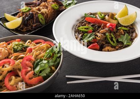 Lecker spicy thai Nudeln in der Nähe von Stäbchen auf Holz graue Oberfläche Stockfoto