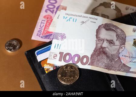 Schwarzes Leder-Etui mit Geld. 1000 Hryven Banknote Nahaufnahme. Krise, Ertrag, Wachstum, Verlust, Diebstahl Entdeckung Stockfoto