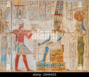 Theben in Ägypten, Karnak, ptolemäischen Tempel des Bbt. Der König, das Tragen eines hemhem Krone und eine gestärkte Lendentuch, bietet ein PEKTORALE Amun zu Gott. Stockfoto