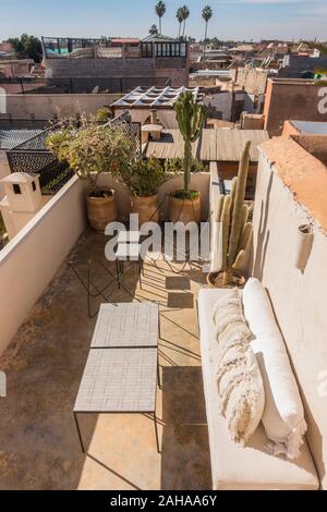 Dachterrasse mit Stühlen in einem Riad, Marrakesch Skyline in Medina, Marrakesch-Safi Region, Marokko, Nordafrika. Stockfoto