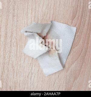 Weiß schmutzige Servietten auf Holz Tisch. gebeizt zerknittertes Papier. Stockfoto