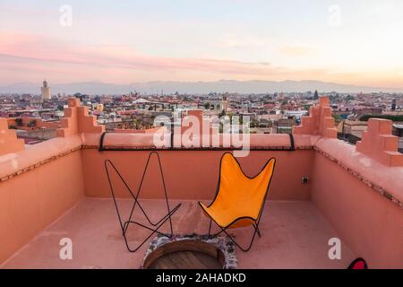 Terrasse mit Stühlen in einem Riad, Marrakesch Skyline der Stadt in Medina, Marrakesh-Safi region, Marokko, Nordafrika. Stockfoto