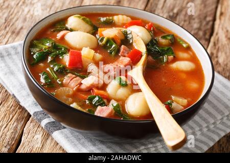 Gnocchi Suppe mit Würstchen,, Tomaten, Spinat und Gemüse close-up in einer Schüssel auf dem Tisch. Horizontale Stockfoto