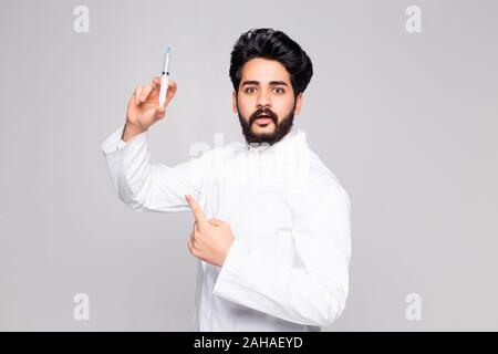 Glückliche junge Arzt holding Spritze auf weißem Hintergrund Stockfoto