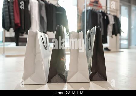 Reihe von Schwarzen und Weißen paperbags stehend auf dem Boden der Boutique
