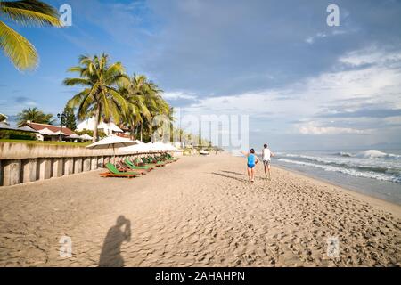 Zwei Männer sind Joggen am Strand entlang. Ein Mann ist, der mit seiner Hand nach links. Stockfoto