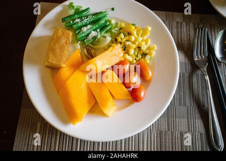 Früchte der verschiedenen Farben sind auf der Platte platziert. Die Gerichte sind neben der Gerichte. Stockfoto