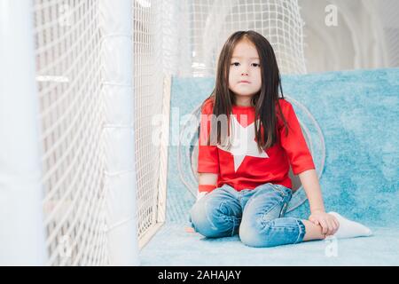 Hübsche kleine asiatische Mädchen mit langem Haar zu tragen Kostüm von Super Girl Stockfoto