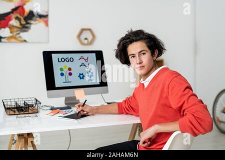 Junge schwere Web Designer mit Stift und Grafiktablett sitzen, Schreibtisch Stockfoto