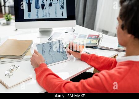 Junge kreative Modedesigner mit Tablet das Blättern durch die neuen Modelle Stockfoto