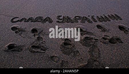 Inschrift Herrlichkeit in die Ukraine mit Schuh Marken auf Islands schwarzen vulkanischen Sand Stockfoto