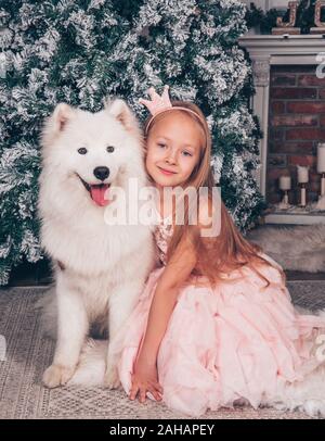 Blonde Mädchen und Samojeden Hund durch das Neue Jahr. Stockfoto