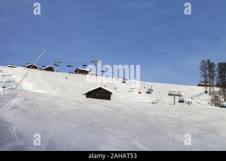 Verschneite Skigebiet mit Schnee grooming Maschine, Sesselbahn und Schneekanonen im Skigebiet vorbereitet. Berge im sonnigen Wintertag. Italienische Alpen. Livigno, Stockfoto