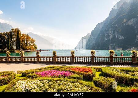 Garda See Promenade mit bunten Blumenbeeten mit wachsenden und blühenden Pflanzen, classic Stone Fence am Rande mit Blumentöpfen mit blühenden fl gebaut Stockfoto