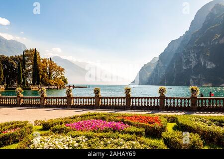 Garda See Promenade mit bunten Blumenbeeten mit wachsenden und blühenden Pflanzen, classic Stone Fence am Rande mit Blumentöpfen mit blühenden fl gebaut Stockfoto