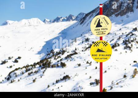 Zeichen in den Bergen zu einem Skigebiet mit Gefahrenhinweisen. Stockfoto