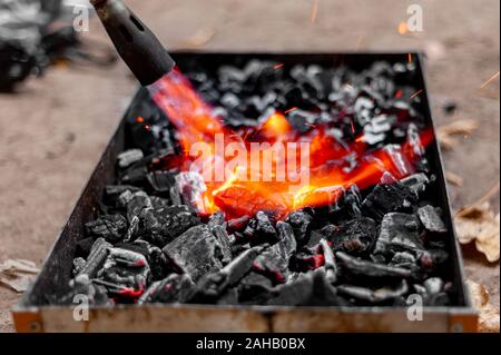 Der Schuß von der Zündung einige Kohlen mit Flamme Stockfoto