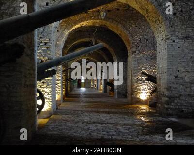 Große militärische Canones Linie einem gewölbten unterirdischen Passage zwischen Steinbögen in Gjirokaster Schloss, in der zum UNESCO-Weltkulturerbe osmanischen Stadt Gjirokastra im Süden von Albanien Stockfoto