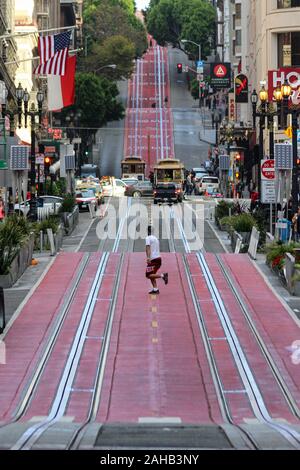 Mann laufen über die Powell Street Cable Car schienen in San Francisco, Vereinigte Staaten von Amerika Stockfoto