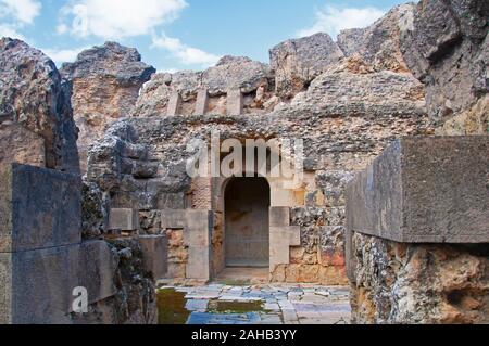 Hellbraun alten verfallenen Mauern mit gewölbter Durchgang des open air. Alte römische Stadt Italica in Sevilla, Spanien Stockfoto