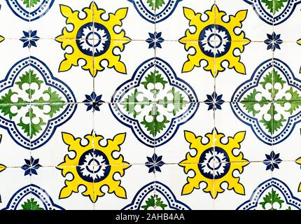 Portugiesische traditionelle Kacheln Azulejos mit blauen, grünen und gelben Blumen Muster auf weißem Hintergrund. Stockfoto