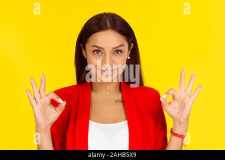 Alles ist in Ordnung. Multikulturelle Modell ok Zeichen mit beiden Händen. Mixed Race Modell auf gelben Hintergrund mit Kopie Raum isoliert. Horizontale Stockfoto