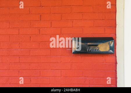 Schwarz Postfach auf orange brick wall Hintergrund Textur Stockfoto