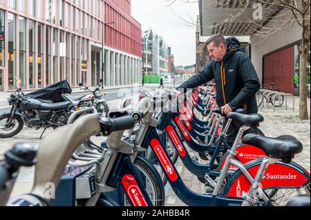 Man mietet ein Santander gesponsert oder Boris City Bike Fahrrad für Mietwagen in London, UK. Stockfoto