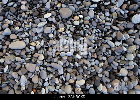 Nasse und trockene runde Steine, Kieselsteine am Strand, Sammlung von Mineralien, Ocean Shore. Stockfoto