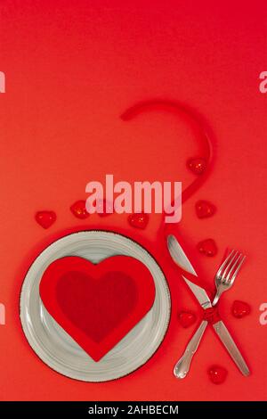 Festliche Tischdekoration für Valentines Tag auf rotem Hintergrund. Valentinstag Konzept. Ansicht von oben. Stockfoto