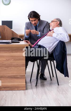 Die männlichen Mitarbeiter leiden von Herzinfarkt im Büro Stockfoto