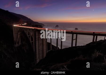 Auto Licht Wanderwege leuchtenden Bixby Bridge auf einem winter Dämmerung Stockfoto