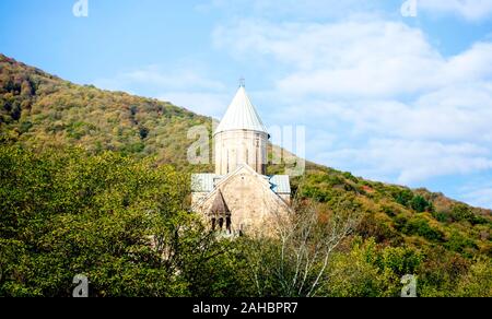 Alte antike christliche Kirche mit Kuppel und ein Kreuz auf einem Berg in einem Wald in Tiflis Georgien vor einem blauen Himmel und Wolken Stockfoto