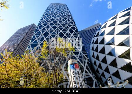 Blick auf den Mode Gakuen Cocoon Tower, auch genannt die riesigen Kokon, Golf - Kugel Gebäude im Vordergrund. Frühling mit blauem Himmel. Shinjuku, Tokyo. Stockfoto