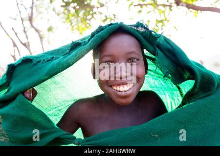 Suri Stamm Junge seinen Kopf Schutz vor der Sonne mit grüner Decke, Omo Valley, Äthiopien Stockfoto