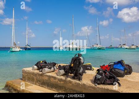 Tauchausrüstung an der Küste von Bonaire mit Segelbooten auf Meer Stockfoto