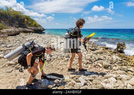 Zwei jungen kaukasischen Taucher am Strand zu Fuß zum Meer Stockfoto