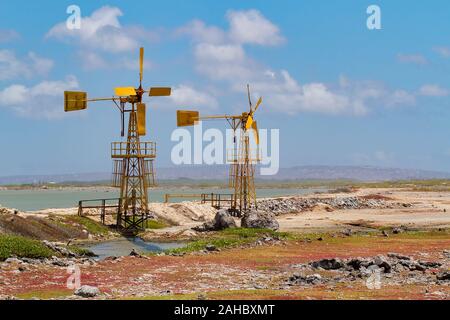 Zwei gelbe Windmühlen für die Salzgewinnung in der Nähe von Wasser auf der Insel Bonaire Stockfoto