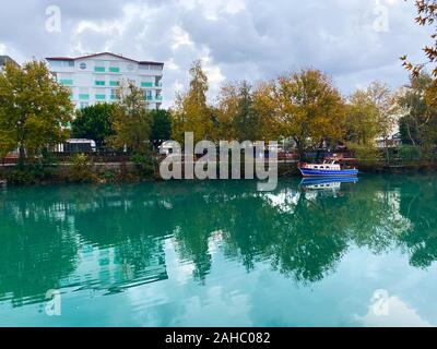 Auf dem See ein Boot vor dem Hintergrund der Häuser und Bäume. Die Türkei. Herbst. Stockfoto