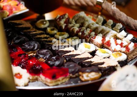 Nahaufnahme von Fach mit köstlichen Kuchen Törtchen in einer Reihe. Frischen bunten süßen Beeren Desserts, schön eingerichtet Stockfoto