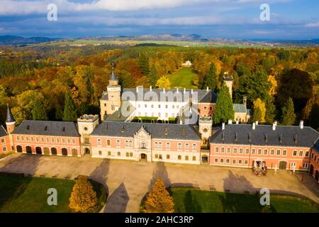 Luftaufnahme von einzigartigen neugotische Gebäude von Schloss Sychrov mit großen Schlosspark, Region Liberec, Tschechische Republik Stockfoto
