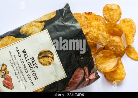 Paket von Marks & Spencer Beef Wellington Hand gekocht Chips geöffnet mit dem verschütteten Inhalt auf weißem Hintergrund verschüttet Stockfoto